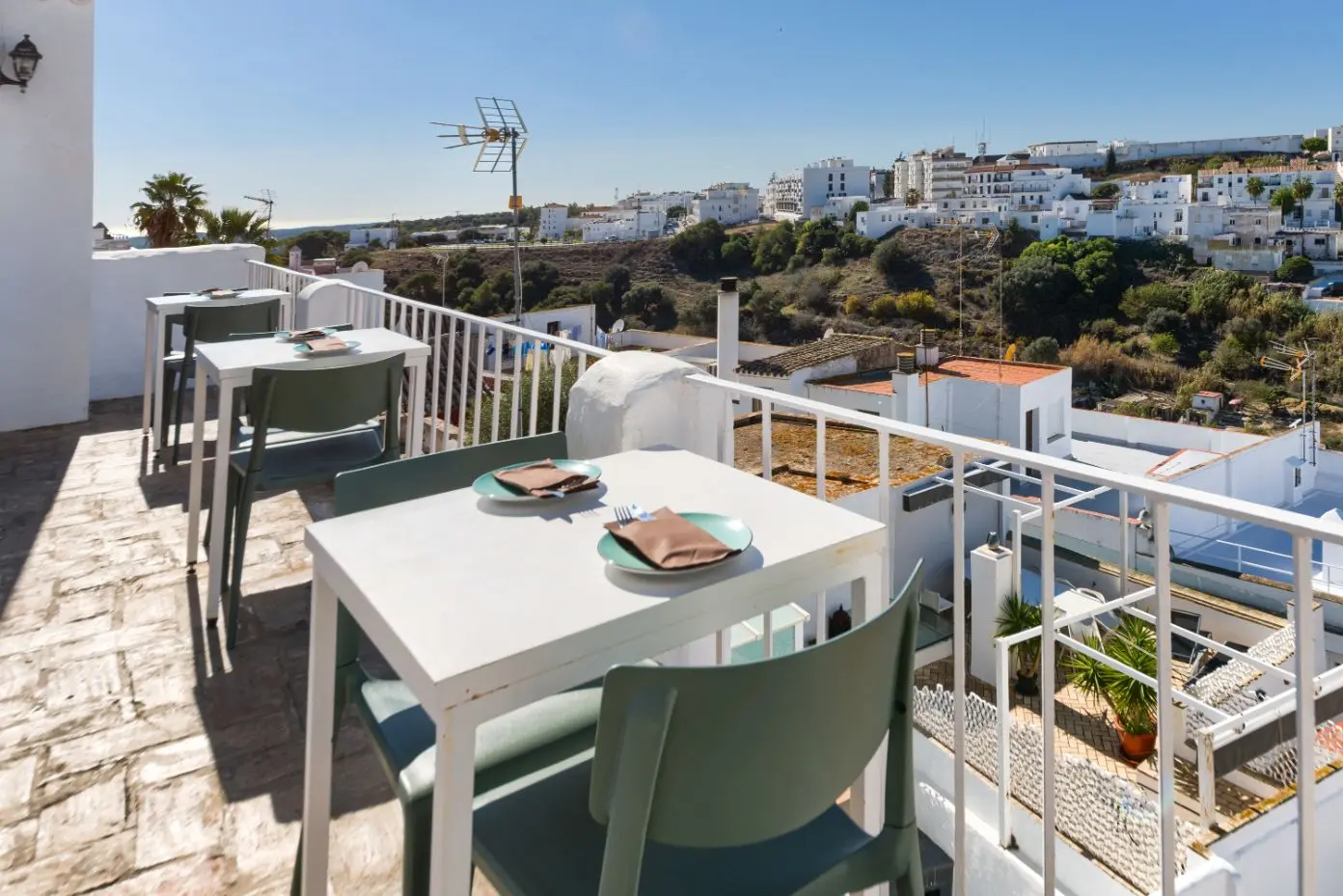 Mesa puesta en la terraza panorámica con vistas al casco histórico de Vejer